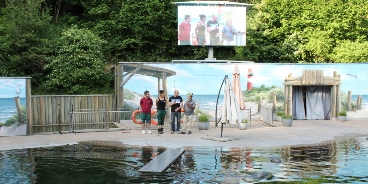 Mundiya Kepanga am 18.05.2022 Vier Personen stehen am Seehundbecken